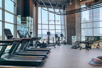 a gym with rows of treadmills and elliptical machines at Frank Porter - 15 Northside Tower 1 in Dubai