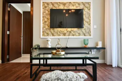a living room with a glass table and a tv at Vera Residence-Canal Viewing Dubai Mall walking 2BR Chic APT in Dubai