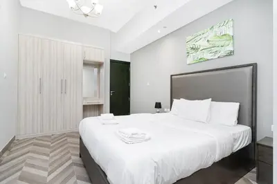 a bedroom with a large white bed with white pillows at Spacious 4bd en-suite apt I Canal view I Fast wifi in Dubai