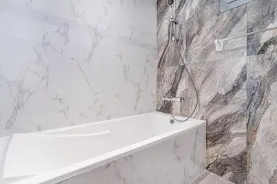 a bathroom with a shower and a white bath tub at Spacious 4bd en-suite apt I Canal view I Fast wifi in Dubai
