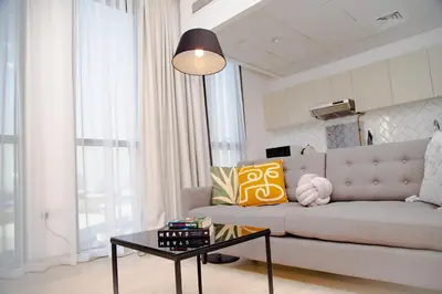a living room with a couch and a table at Green community - Tennis, streetball - 15 mins sea in Dubai