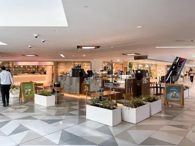 a store with tables and potted plants in a building at Trophy - Euphoria Eclipse Suite in 29th floor in Burj Royale in Dubai