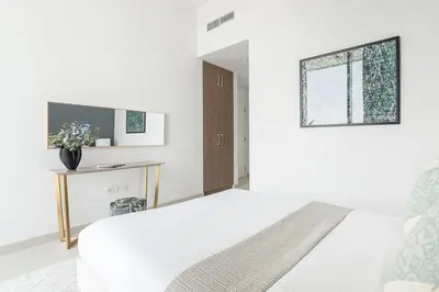 a white bedroom with a bed and a window at Frank Porter - The Grand in Dubai