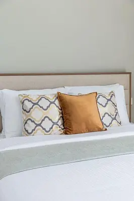 a bed with several pillows on top of it at Frank Porter - The Grand in Dubai