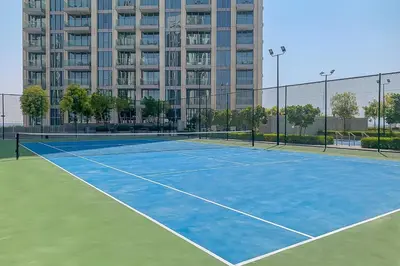 a tennis court in front of a large building at Frank Porter - The Grand in Dubai