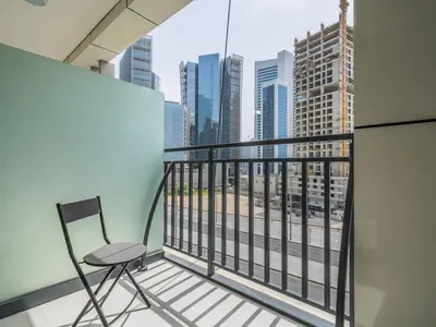 a chair on a balcony with a view of the city at Business Bay's Coziest Hideaway With Balcony in Dubai