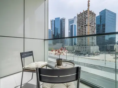 a table and chair in a room with a view of a city at Business Bay's Coziest Hideaway With Balcony in Dubai