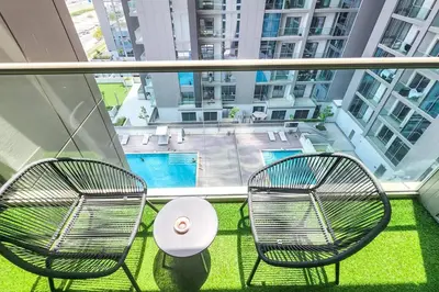 two chairs and a table on a balcony with a pool at STAY BY LATINEM Luxury 1BR Holiday Home CVR A703 near Burj Khalifa in Dubai