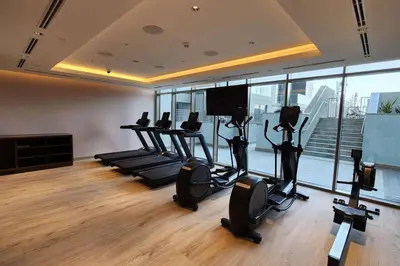 a gym with treadmills and ellipticals in a room with windows at STAY BY LATINEM Luxury 1BR Holiday Home CVR A703 near Burj Khalifa in Dubai