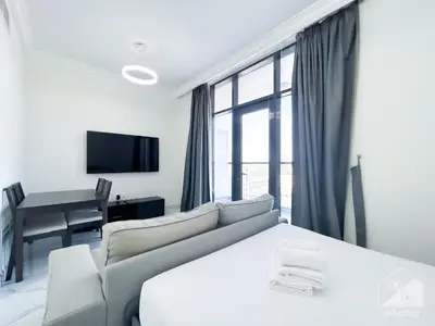 a living room with a couch and a table at Spacious Studio with balcony in AL Majan in Dubai