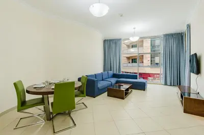 a living room with a blue couch and a table at RH- Exquisite & Spacious 01 BR, Near Mall of the Emirates in Dubai
