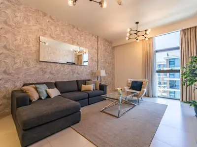 a living room with a couch and a table at Dazzling 1BR in Park Point - Dubai Hills in Dubai