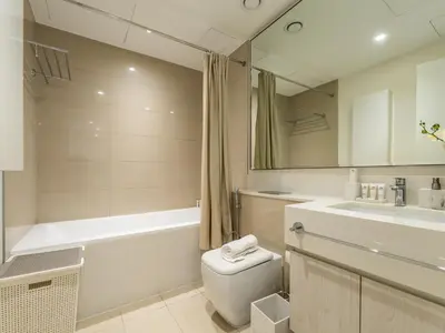 a bathroom with a toilet and a tub and a sink at Dazzling 1BR in Park Point - Dubai Hills in Dubai