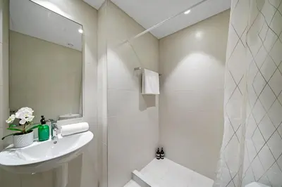 a white bathroom with a sink and a mirror at Extravagant 3BR + kid's room w/ Burj Khalifa view in Dubai