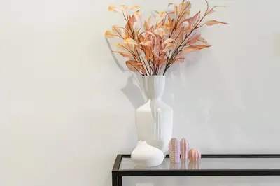 a white vase with flowers on a table at Extravagant 3BR + kid's room w/ Burj Khalifa view in Dubai