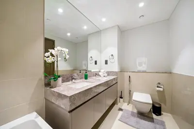 a bathroom with two sinks and a toilet and a mirror at Extravagant 3BR + kid's room w/ Burj Khalifa view in Dubai