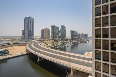 a bridge over a river in a city with buildings at Frank Porter - Damac Voleo in Dubai
