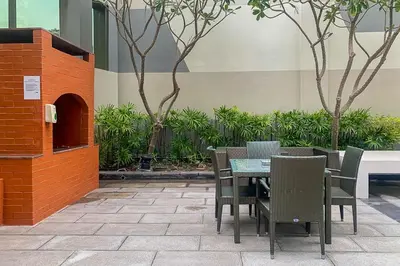 a patio with a table and chairs and plants at Frank Porter - Damac Voleo in Dubai