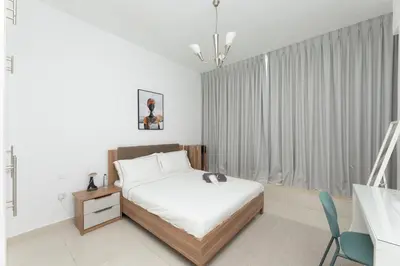 a bedroom with a bed and a chair and a window at Waterfront With Stunning View! in Dubai