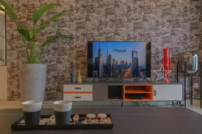 a living room with a tv on a entertainment center at Paramount Tower Hotel and Residences with Infinity Sky Pool in Dubai