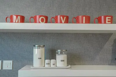 a shelf with two jars of milk and red coffee cups at Paramount Tower Hotel and Residences with Infinity Sky Pool in Dubai