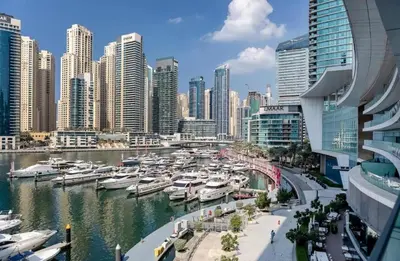 a group of boats docked in a harbor in a city at Dubai Marina larivera in Dubai