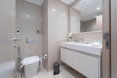 a bathroom with a sink and a toilet and a mirror at Vogue Downtown Burj Royale near Dubai Mall and Burj Khalifa ,Two Bedroom Apartment with large Balcony and Access to all Amenities in Dubai