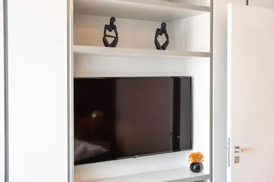 a tv in a living room with a shelf at Sunrise Bay with treasure stunning harbour view by Suiteable in Dubai