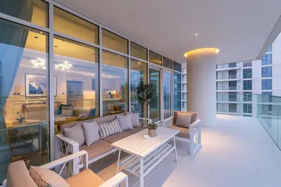 a balcony with a couch and a table on a building at Sunrise Bay with treasure stunning harbour view by Suiteable in Dubai