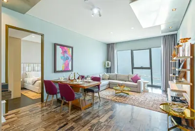 a living room with a table and a couch at Luxury 2BR Panoramic Marina Views High Floor in Dubai