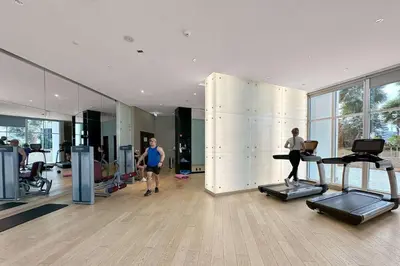 a gym with two people running on treadles in a room at ALiving Classy Private Studio I Canal Views I DAMAC Maison Prive A- 2111 in Dubai