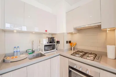 a kitchen with a stove and a microwave at EasyGo - Sobha Waves 1 Bedroom & Study Modern in Dubai