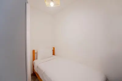 a white bedroom with a bed and a lamp at EasyGo - Sobha Waves 1 Bedroom & Study Modern in Dubai