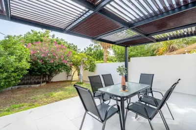 a patio with a table and chairs under a pergola at GuestReady - Springs Serenity near Golf Club in Dubai