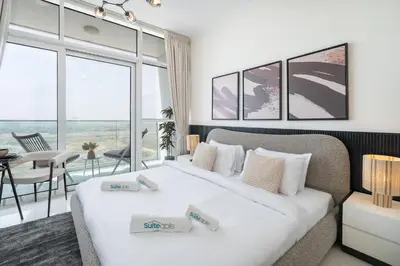 two beds in a room with a large window at Executive Studio in Damac Hills by Suiteable in Dubai