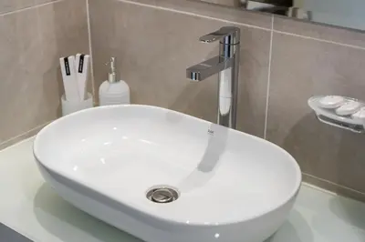 a white sink with a faucet in a bathroom at Executive Studio in Damac Hills by Suiteable in Dubai