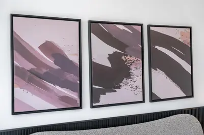 four frames hanging on a wall in a room at Executive Studio in Damac Hills by Suiteable in Dubai