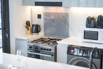 a kitchen with a stove and a microwave at Canal front apartment with Burj Khalifa view by Suiteable in Dubai
