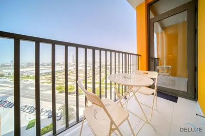a balcony with a table and chairs and a view at Polished 1BR at Noor 1 Midtown Dubai Production City by Deluxe Holiday Homes in Dubai