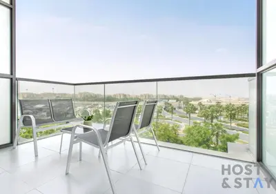 a room with two chairs and a table and windows at Studio in Jasmine, Damac Hills - Host & Stay in Dubai