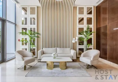 a living room with two chairs and a coffee table at Studio in Jasmine, Damac Hills - Host & Stay in Dubai