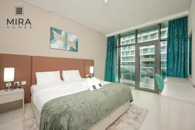 a bedroom with a bed and a large window at Mira Holiday Homes - Lovely 1 bedroom with beach access in Dubai