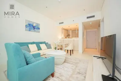 a living room with a blue couch and a table at Mira Holiday Homes - Lovely 1 bedroom with beach access in Dubai