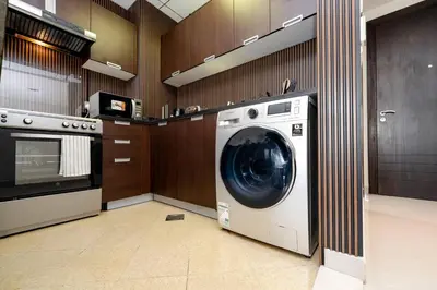 a laundry room with a washing machine in a kitchen at Special Rates - Elegant Studio - Golf Views in Dubai
