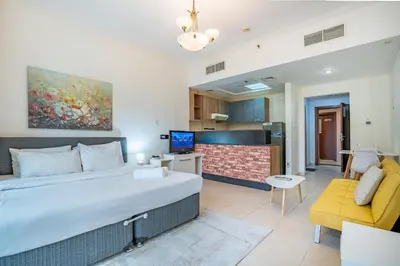 a bedroom with a large bed and a yellow couch at RH- Studio Retreat, Walk away to Burj Khalifa and Dubai Mall in Dubai