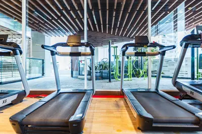 a gym with two treadmills in a room at Waves Holiday Homes - Chic Studio With Balcony Overlooking City Views in Dubai