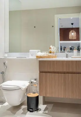 a bathroom with a toilet and a sink and a mirror at Manzil - 1BR Home in Port de la Mer w Lake Access in Dubai