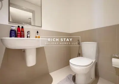 a bathroom with a white toilet and a sink at Sunrise Bay 3BR EMAAR Beachfront Dubai Harbour by Rich Stay in Dubai