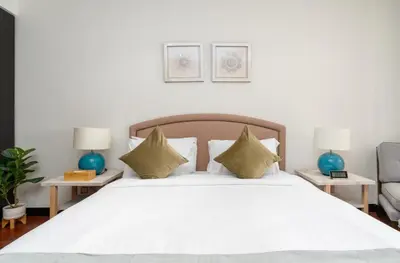 a bedroom with a large white bed with two tables at Lux BnB I Palm Jumeirah Resort I Palm Views in Dubai