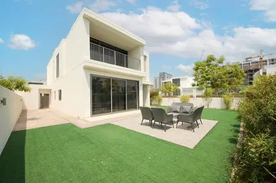 a large white house with a yard with green grass at NewArabian Dubai Hills Sidra Villa in Dubai